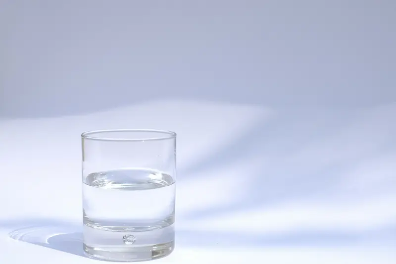 Full drinking glass of water standing on a tabletop